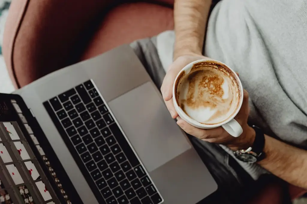 Man comparing two coffee shop listings on laptop, representing commercial investigation intent in local search
